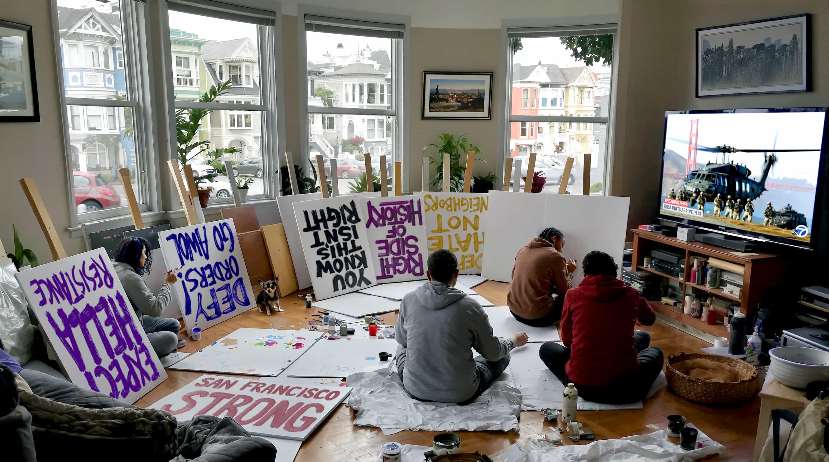 A group of young people sit in a San Francisco living room painting protest signs.